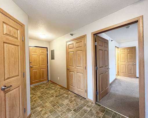 the living room and entryway of a house with wooden doors
