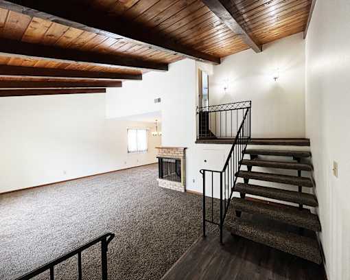A room with a staircase and a fireplace.