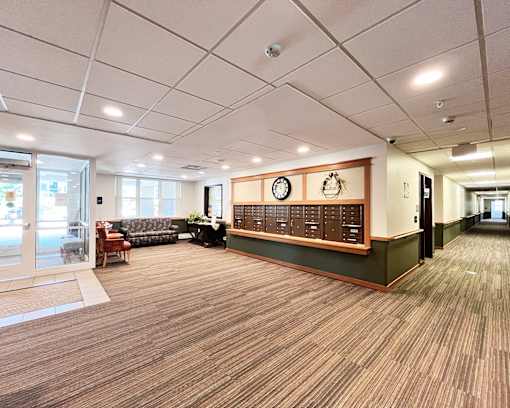 A long hallway with a couch and a clock on the wall.