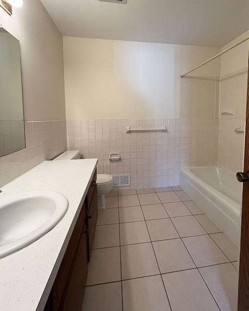 A white bathroom with a sink, toilet and bathtub.