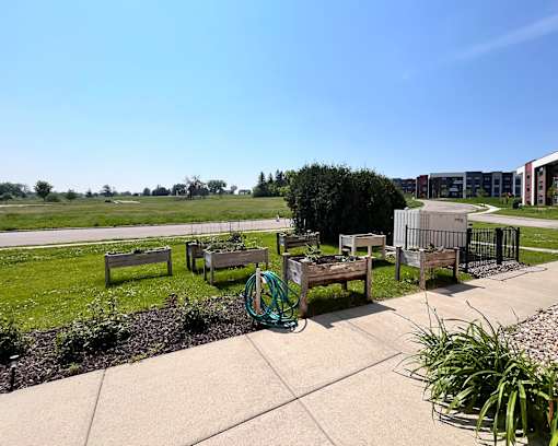 A playground with a green hose and a bench.