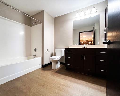 A bathroom with a white tub, toilet, and sink.