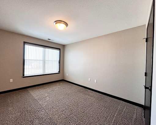 A room with a window and a ceiling light.