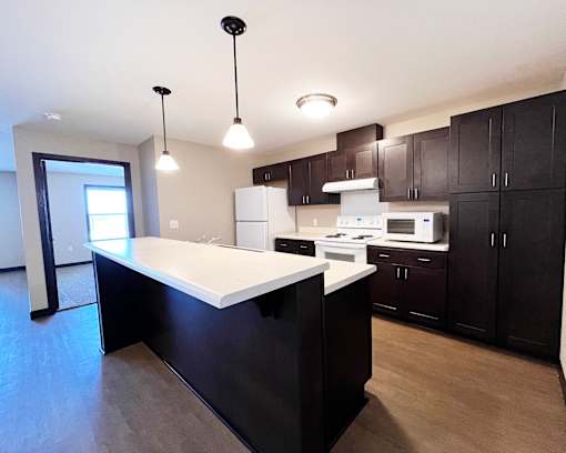 A kitchen with a white countertop and black cabinets.