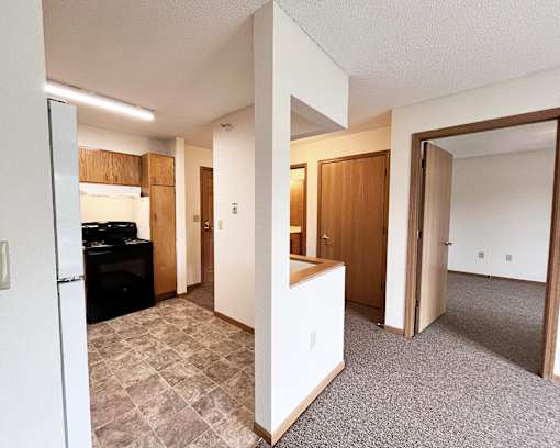 A kitchen area with a refrigerator, oven, and cabinets.