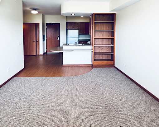 A kitchen with a white counter top and a wooden floor.