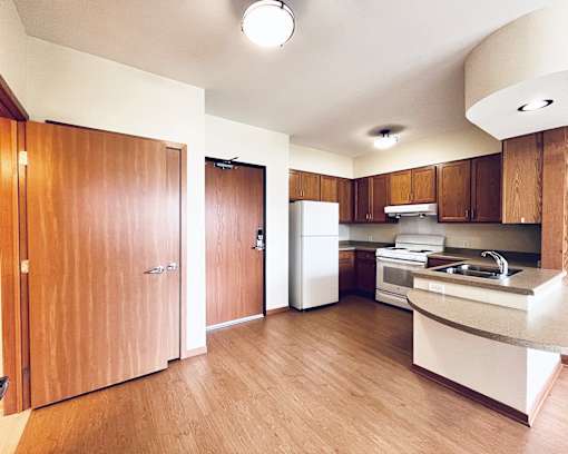 A kitchen with wooden floors and cabinets.