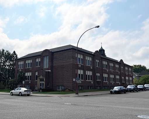 A large brick building with a street in front of it.