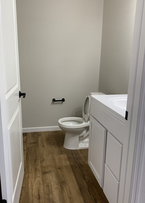 a bathroom with a toilet sink and toilet paper roll