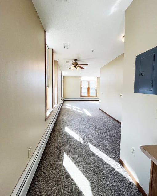 an empty living room with a ceiling fan