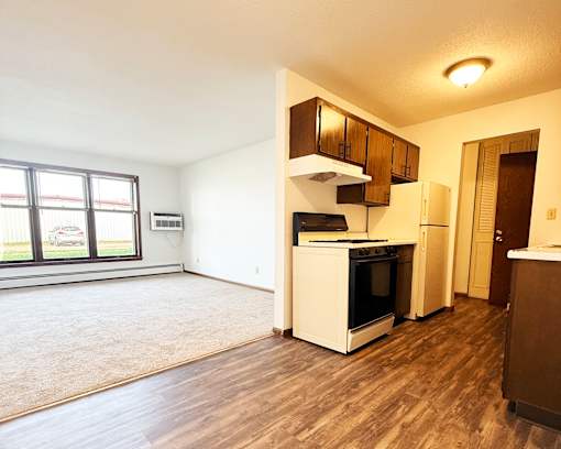 A kitchen with a white oven and wooden cabinets.
