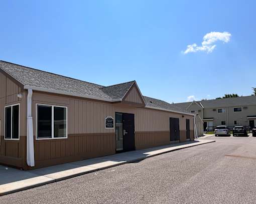 A building with a brown facade and a black door is under a clear sky.
