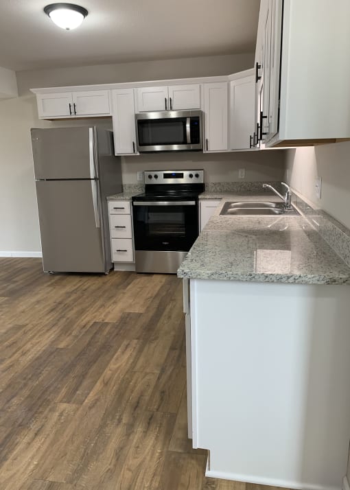 a kitchen with white cabinets and stainless steel appliances
