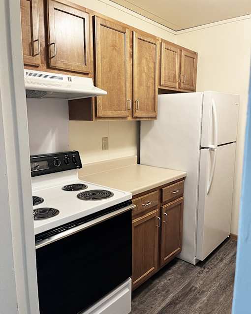 a kitchen with white appliances and wooden cabinets and a refrigerator