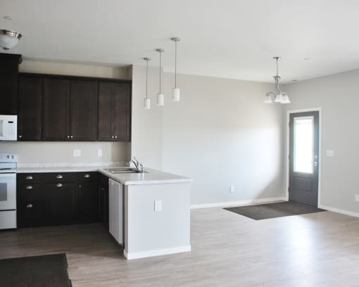 a kitchen with white countertops and dark cabinets
