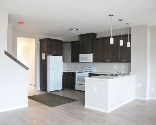 a kitchen with dark wood cabinets and white appliances
