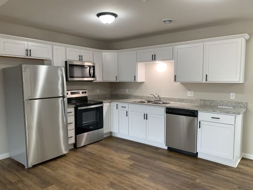 a kitchen with white cabinets and stainless steel appliances