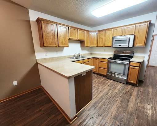 A kitchen with wooden cabinets and a white countertop.