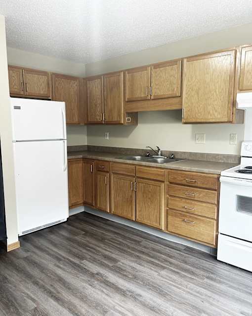 A kitchen with wooden cabinets and a white refrigerator.