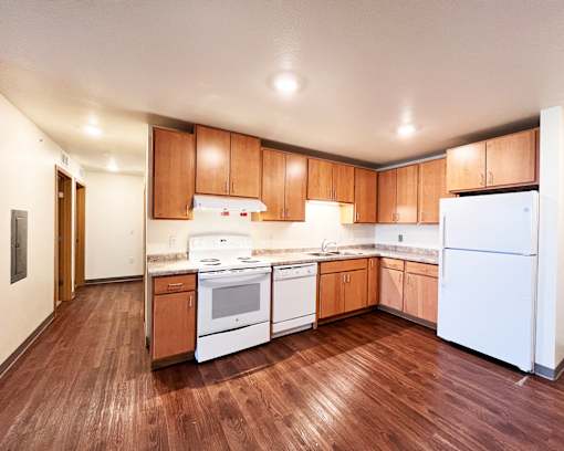 A kitchen with white appliances and wooden cabinets.