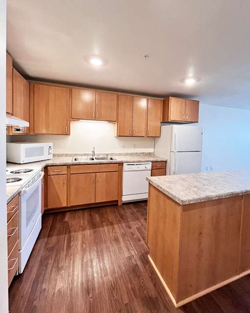 A kitchen with wooden cabinets and a white fridge.