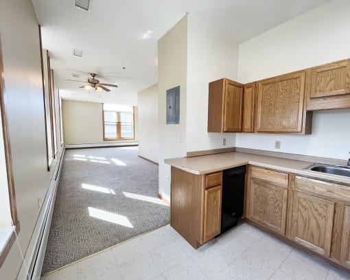 an empty kitchen and living room with a ceiling fan