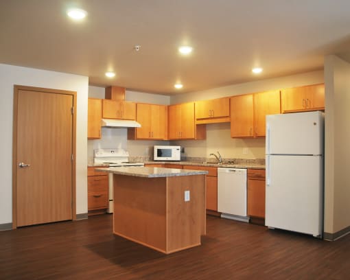 a kitchen with a white refrigerator freezer next to a stove top oven