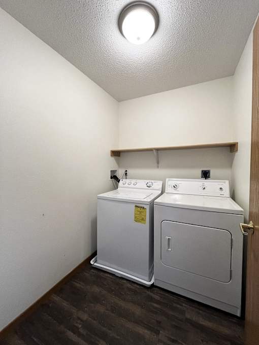 a room with two washers and a dryer in it and a white wall
