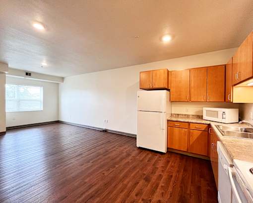 A kitchen with white appliances and wooden cabinets.