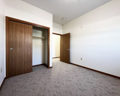 an empty room with a door to a closet