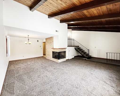 A large open room with a fireplace and a staircase.