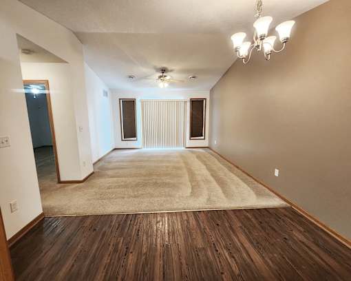 A room with wooden floors and a rug in the middle.