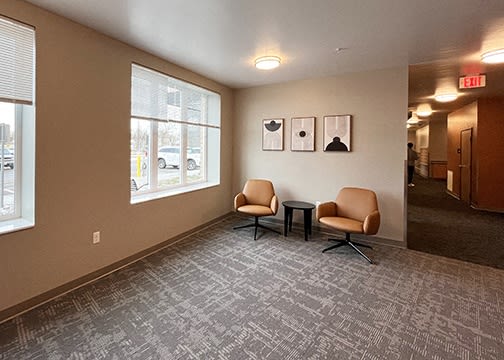a room with two chairs and a table in front of a window