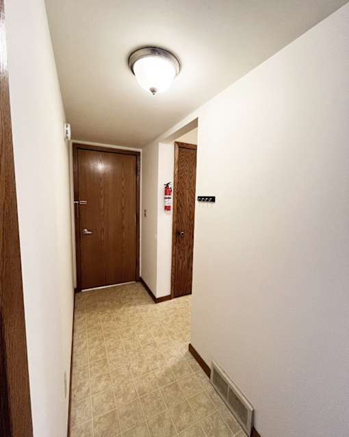 A hallway with a door on the left and a door on the right.