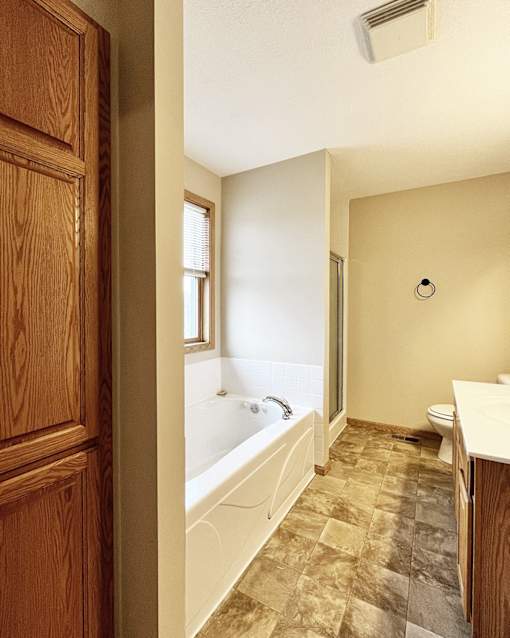 A bathroom with a tub, toilet, and sink.
