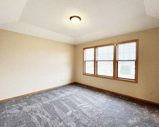 A room with a carpeted floor and a window.