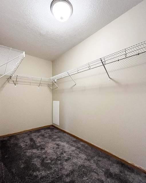 Empty room with a grey carpet and a white ceiling.
