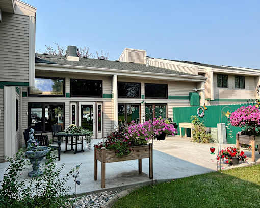 A house with a green wall and a wooden bench in front of it.
