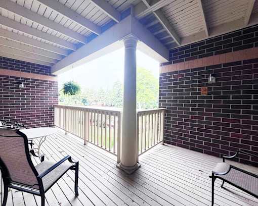 A balcony with a table and chairs.