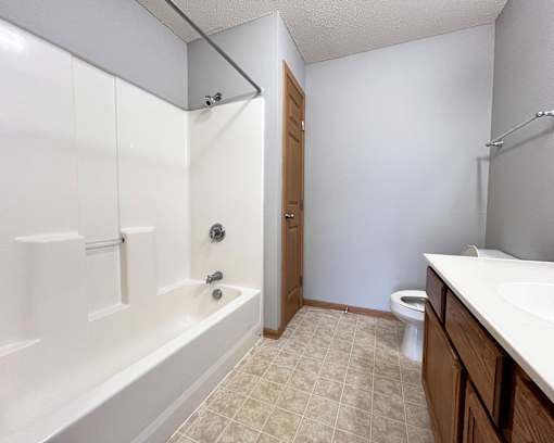 A white bathroom with a toilet, sink, and bathtub.