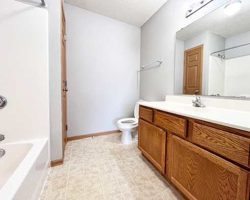 A white bathroom with a toilet, sink, and bathtub.
