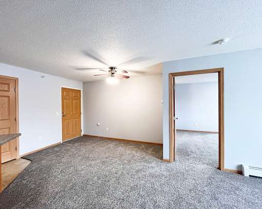 A room with a ceiling fan and a carpeted floor.