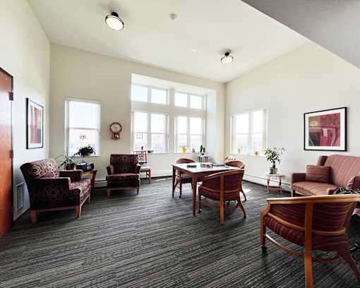 A living room with a couch, chairs, and a table.