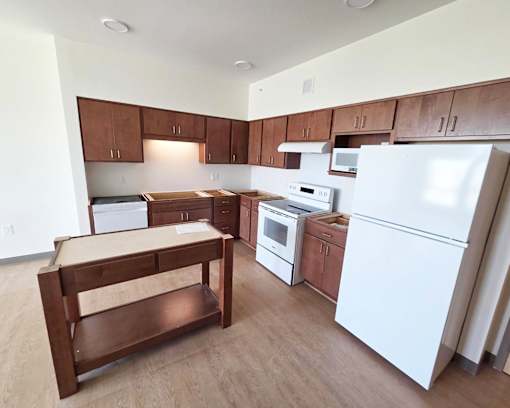 A kitchen with white appliances and wooden cabinets.