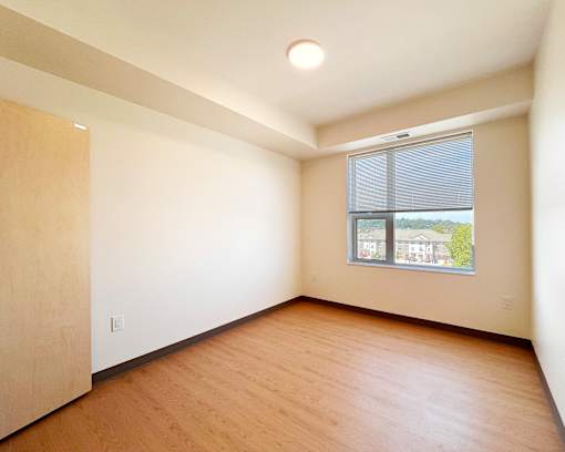 Empty room with wooden floor and a window.