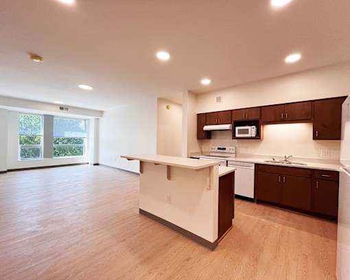 A kitchen with a white island and brown cabinets.