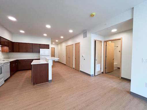 A kitchen with wooden floors and white walls.
