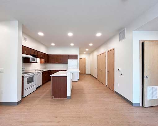 A kitchen with white appliances and wooden cabinets.