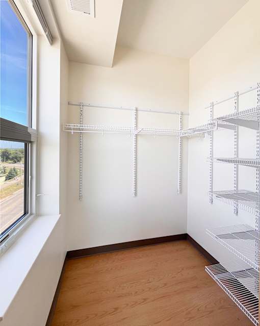A room with a window and shelving units.