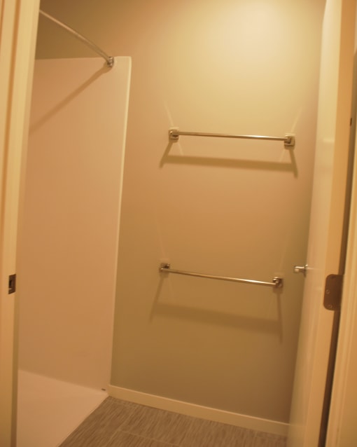 a small bathroom with a shower and a towel rack